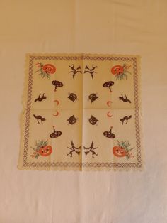 two napkins with different designs on them sitting on a white tablecloth covered surface