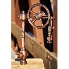 an old fashioned water faucet is shown on a wooden table with metal fittings