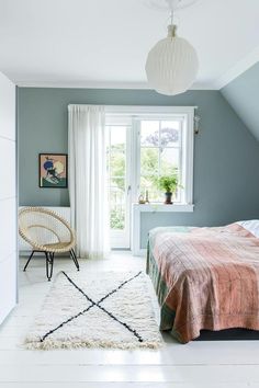 a bedroom with blue walls and white floors