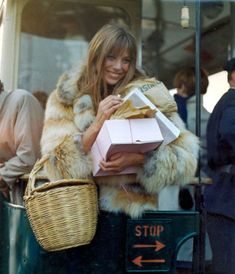 a woman in fur coat carrying shopping bags