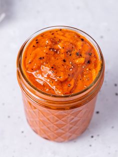 a jar filled with sauce sitting on top of a table