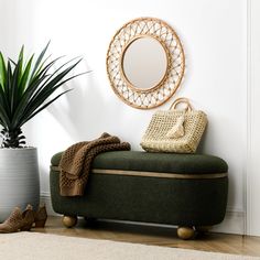 a round mirror on the wall above a green bench with a blanket and shoes next to it