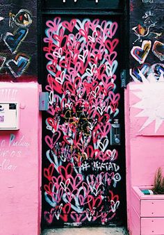 a pink door with lots of hearts painted on it