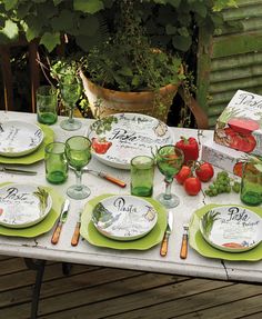 the table is set with plates, glasses and other things to eat on it's outdoor patio