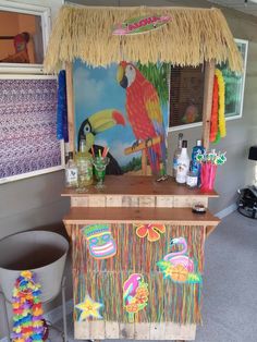 a tropical themed bar with colorful decorations on the top and bottom, next to a trash can