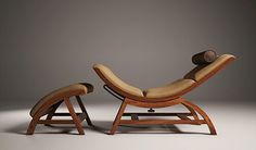 a wooden chair and footstool sitting next to each other in front of a gray background