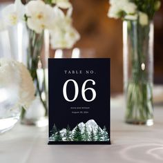 the table numbers are displayed in vases with flowers