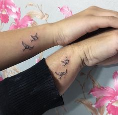 two people with matching tattoos on their arms and wrist, one has a small bird tattoo on it's left arm