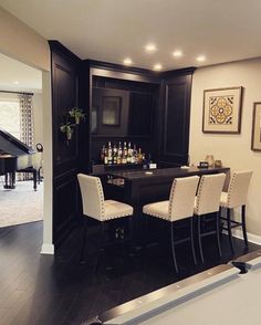 a pool table and some chairs in a room with a piano on the far wall