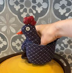 a person is holding a small toy chicken