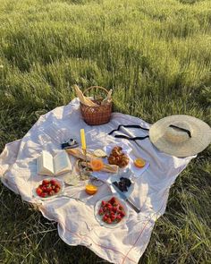 a picnic is set out in the middle of a field with strawberries and cheese