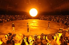 a group of people standing on top of a stage in front of a large crowd