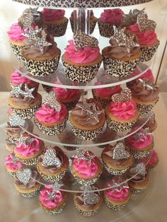 a three tiered cake with cupcakes on it