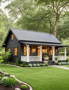 a small black house with white trim and windows on the front porch is surrounded by lush green grass