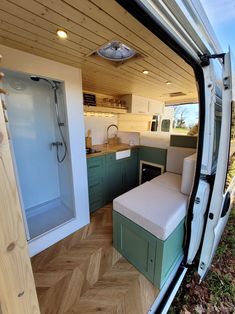 the interior of a camper van with its door open and a kitchen in the back