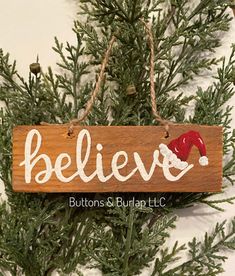 a christmas ornament hanging from a tree with the word believe written on it