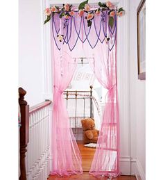 a teddy bear is sitting on the stairs in front of a pink curtained window