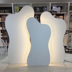 a large white sculpture sitting on top of a tiled floor next to a book shelf