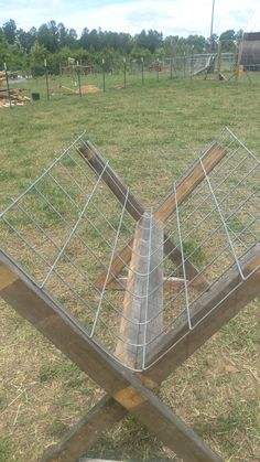 a metal cage sitting on top of a wooden table in a field next to a fire hydrant