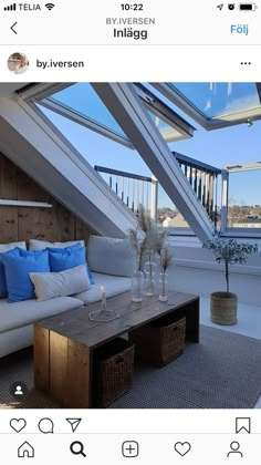 a couch and table in a room with skylights on the roof above it,