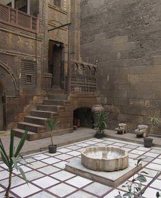 a courtyard with steps and potted plants