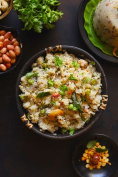 rice and beans are served in black bowls on a dark surface with green leaves around it