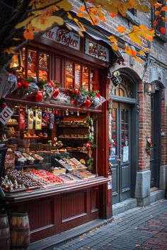 a street scene with focus on the storefronts and autumn leaves hanging from the trees