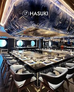 the interior of a restaurant with tables and chairs in front of an artisticly designed ceiling