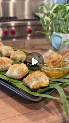 some food is sitting on a plate with green leaves next to it and a potted plant in the background