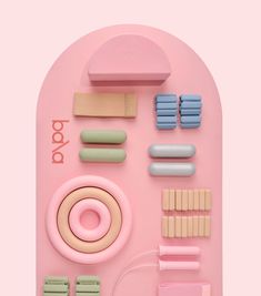 an assortment of pastel colored objects arranged on a pink surface with the word pop written above it