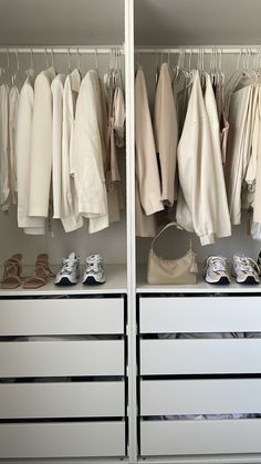 an organized closet with white drawers and clothes hanging on the rails, shoes and handbags