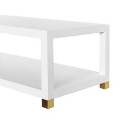 a white coffee table with gold legs and a shelf on the bottom that is open