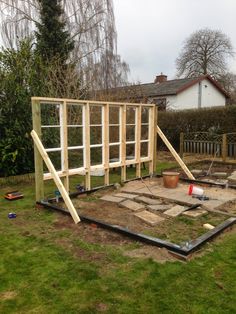 a house being built in the middle of a yard with wooden framing on top of it