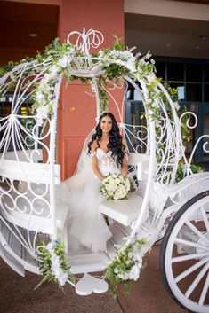 a bride sitting in a white horse drawn carriage