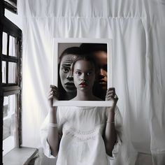 a woman holding up a photo in front of her face