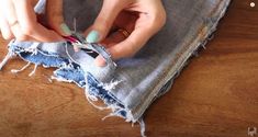 a woman is cutting through some fabric with scissors and sewing needles on top of it