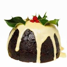 a chocolate bundt cake with icing and holly on top, sitting on a white surface