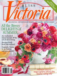 a magazine cover with flowers in a vase on top of a table and books next to it