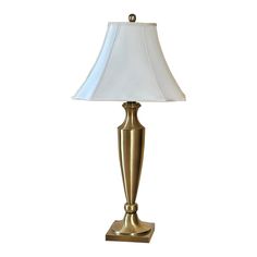 a gold lamp with a white shade on it