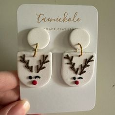 a pair of earrings with reindeer's head painted on the front and back of them