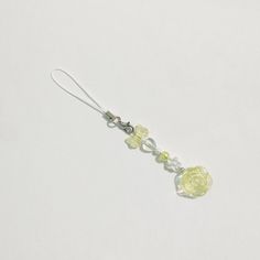 a pair of yellow and clear glass beads hanging from a silver earwire on a white background