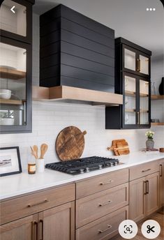 an image of a kitchen setting with black cabinets and white counter tops on the wall