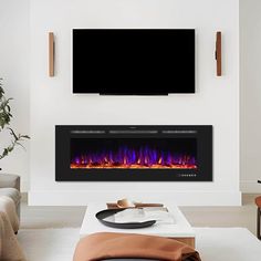 a living room with a large television mounted on the wall and a fire place in front of it