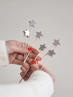 a person holding five silver stars on toothpicks