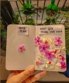 a person holding up a small book with flowers on it and the words, your plan, what god plans for you