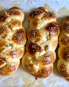 four hot cross buns with sesame seeds on them