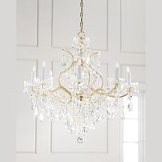 a chandelier hanging from the ceiling in a room with white walls and doors