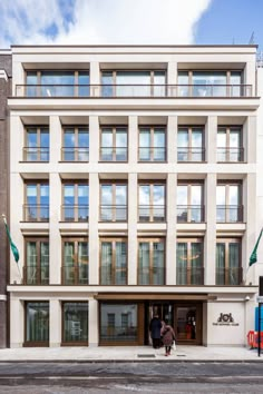 an apartment building with lots of windows on the front and side of it's facade