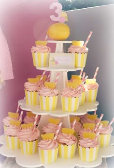 cupcakes are stacked on top of each other with pink and yellow frosting