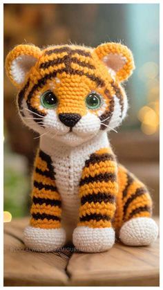 a small stuffed tiger sitting on top of a wooden table